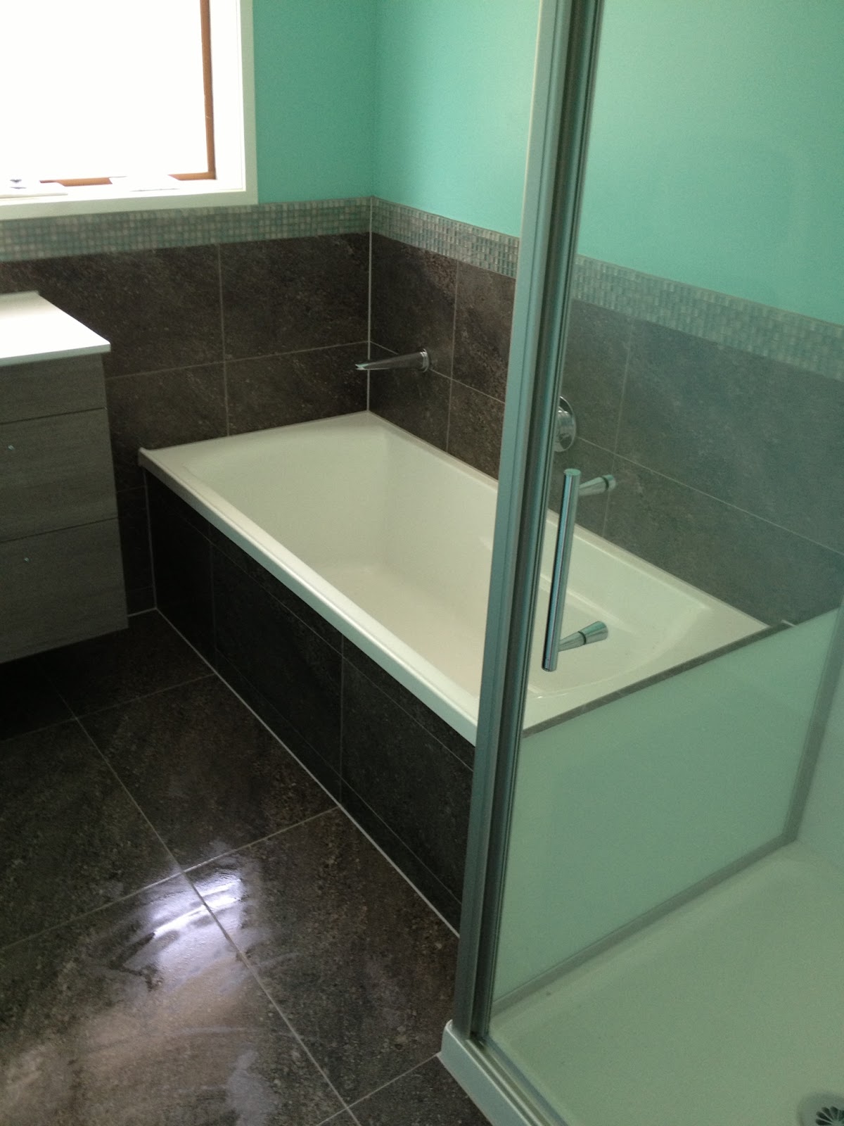 Dark stone bathroom with mosaic border